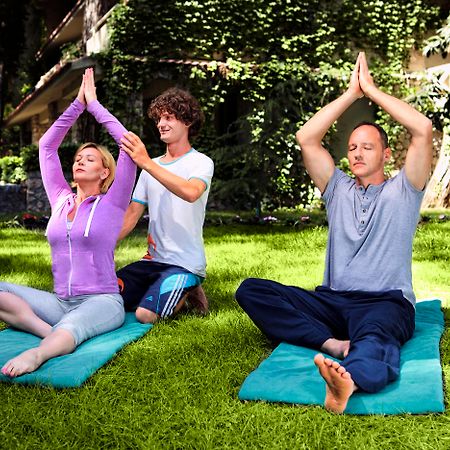 Marti Myra Hotell Tekirova Eksteriør bilde A yoga teacher assists students with their practice.