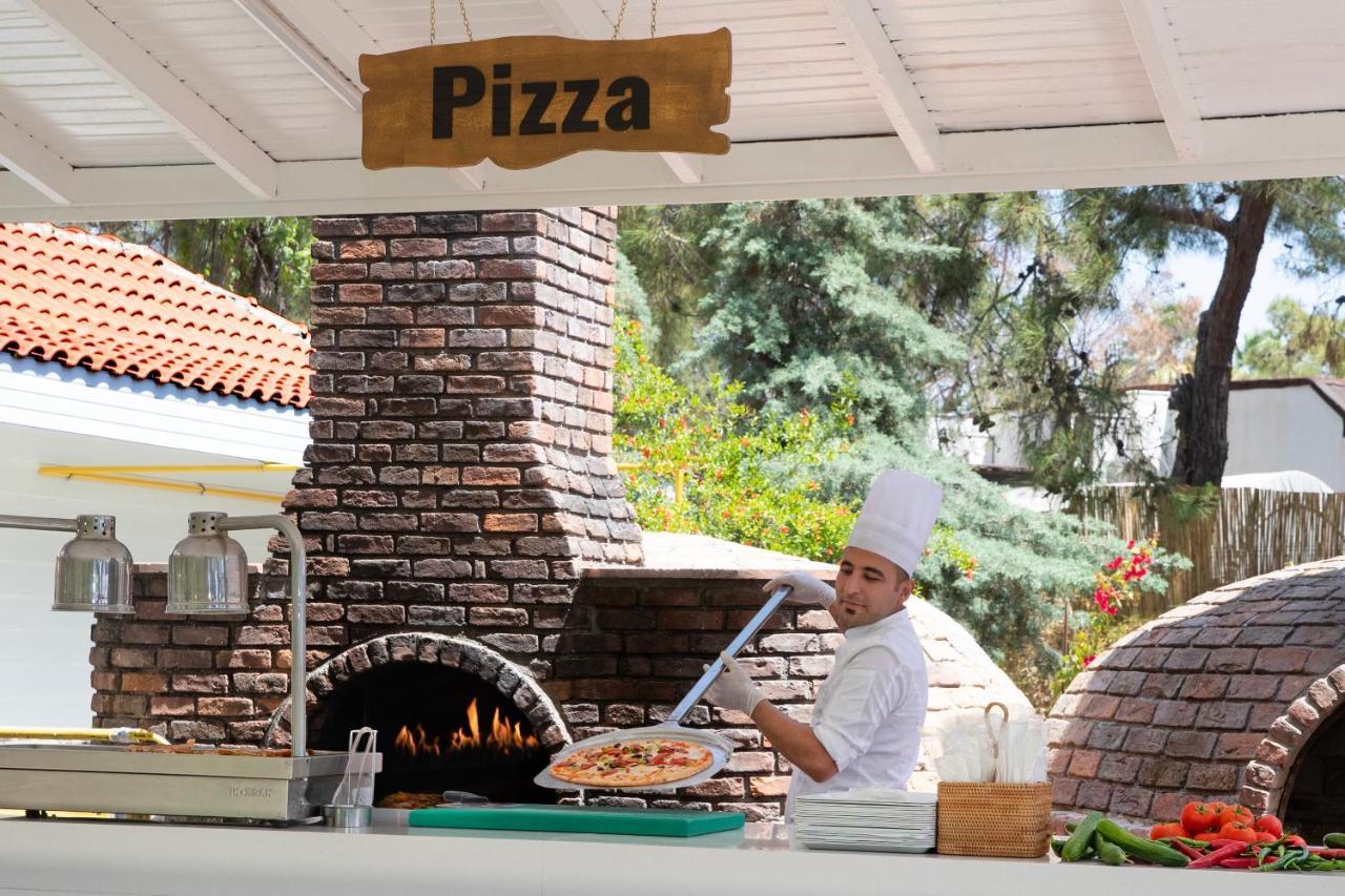 Marti Myra Hotell Tekirova Eksteriør bilde Pizza being prepared in a wood-fired oven